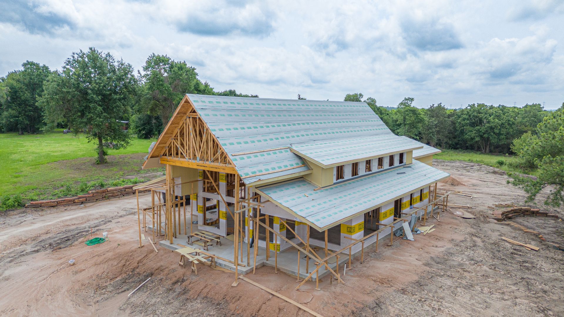 An aerial view of a house under construction in a field.