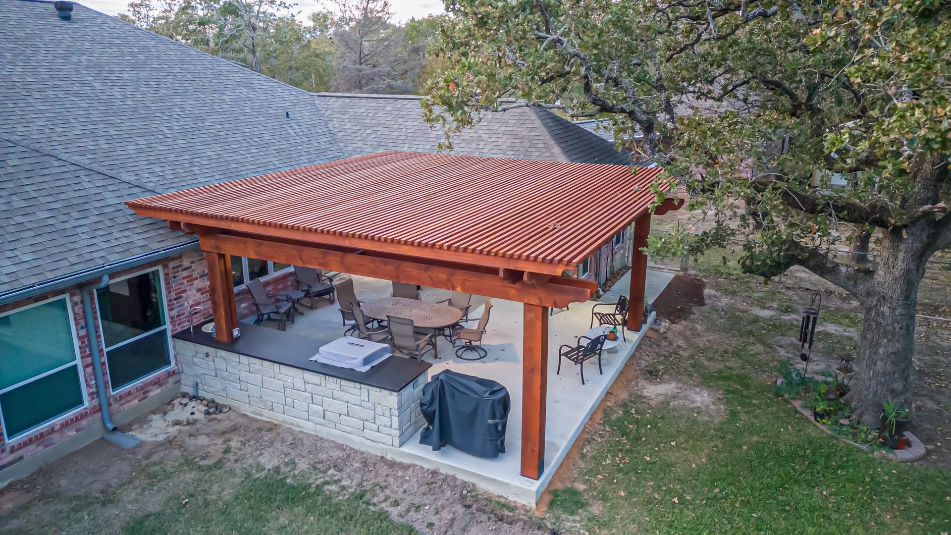An aerial view of a patio with a table and chairs under a pergola.