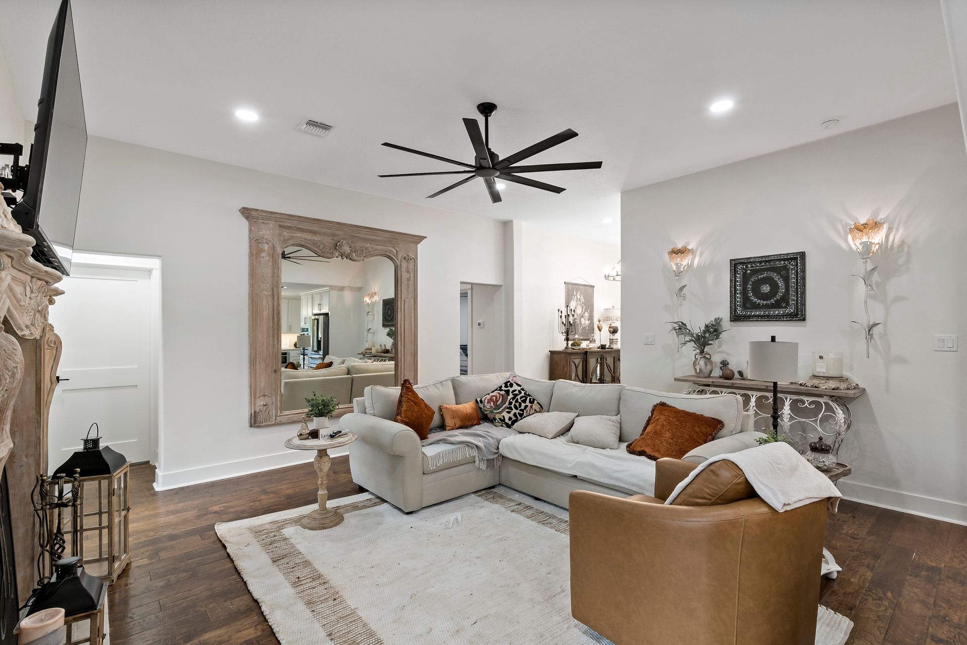 A living room with a couch , chair , fireplace and ceiling fan.