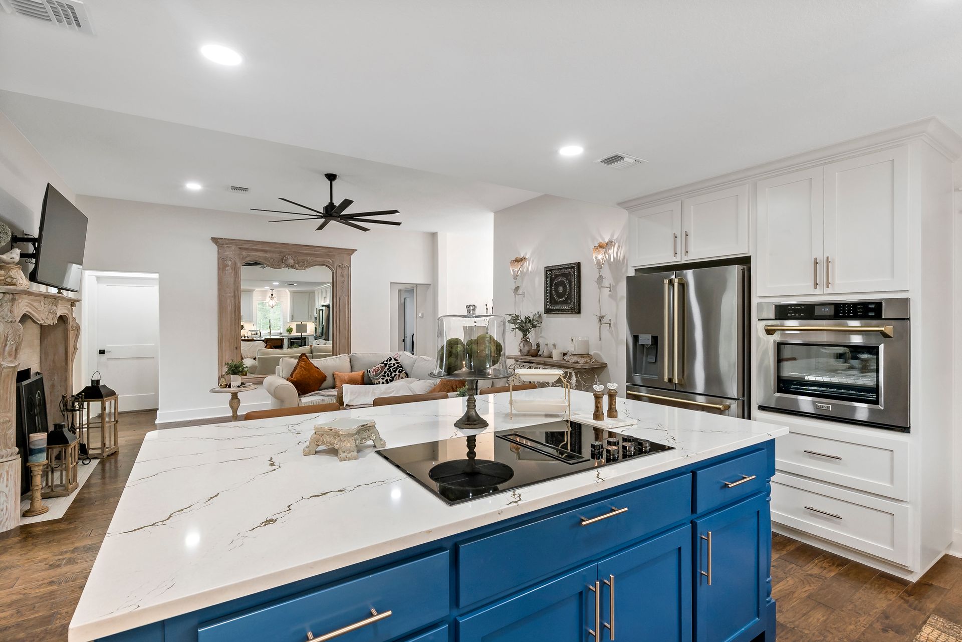 A kitchen with blue cabinets , white counter tops , stainless steel appliances and a large island.