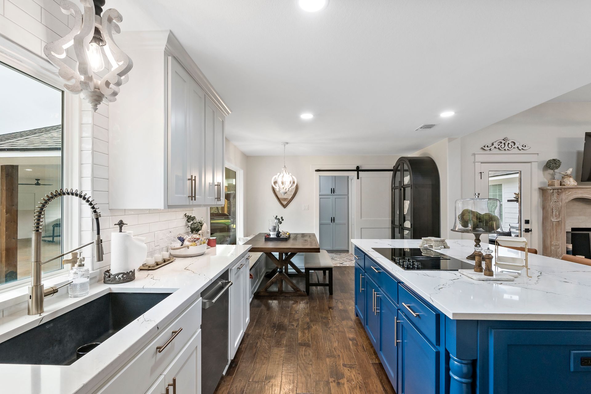 A kitchen with blue cabinets and white cabinets and a large island.