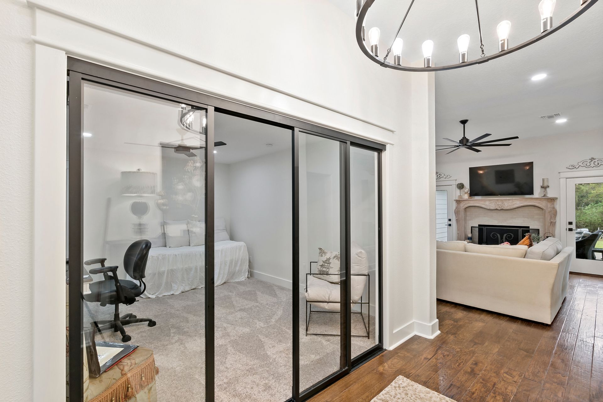 A living room with sliding glass doors leading to a bedroom.