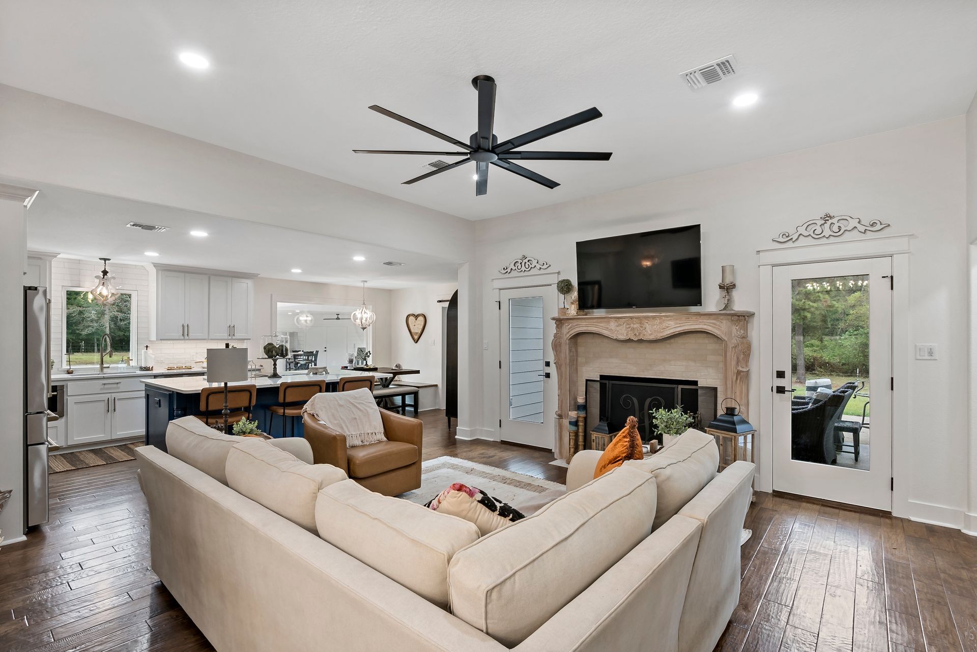 A living room with a couch , fireplace , television and ceiling fan.