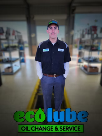 Mechanic in a black uniform stands in a garage at EcoLube, oil change and service.