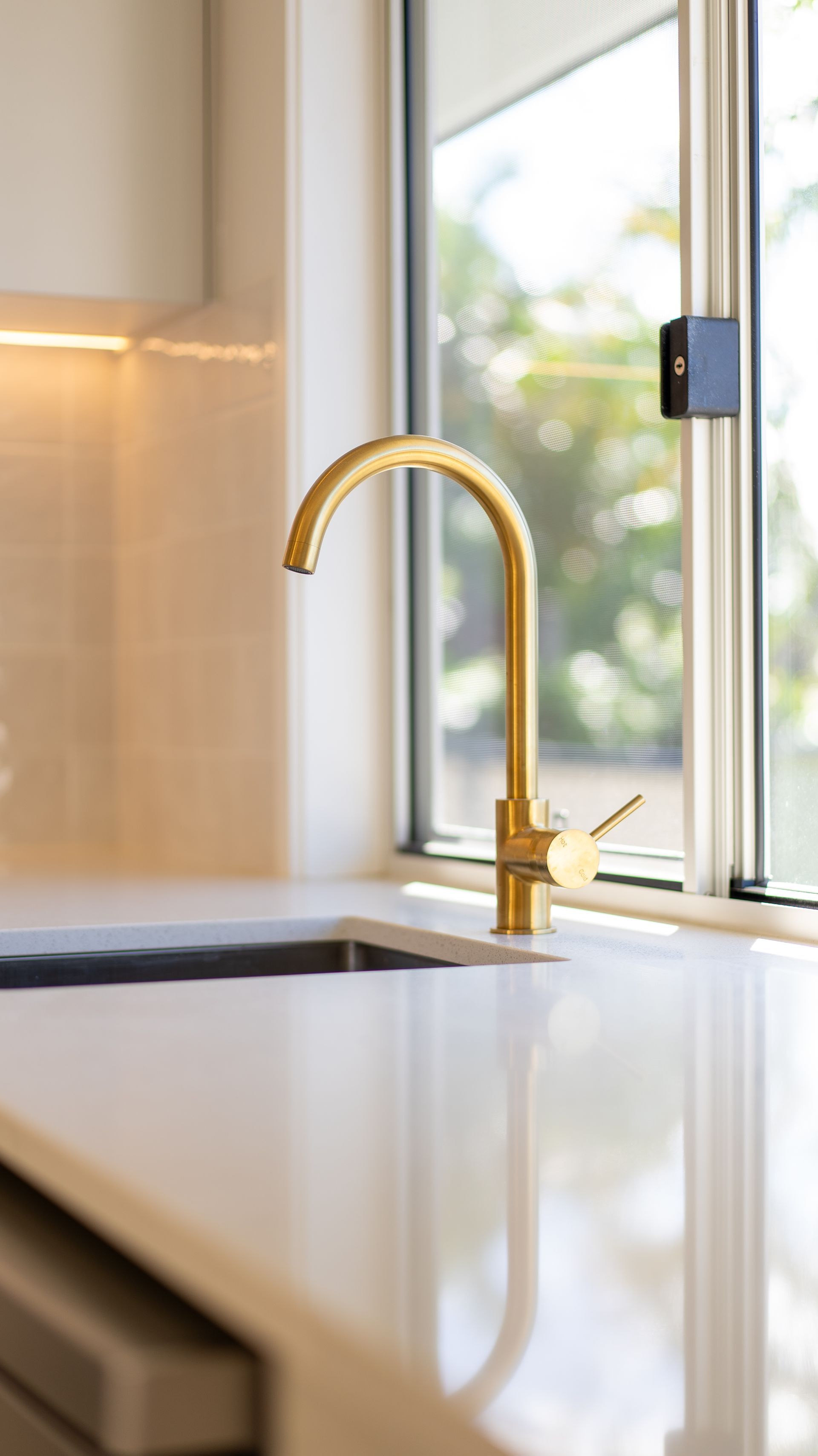 Gold tapware in a kitchen renovation by WCC Kitchens and Cabinets