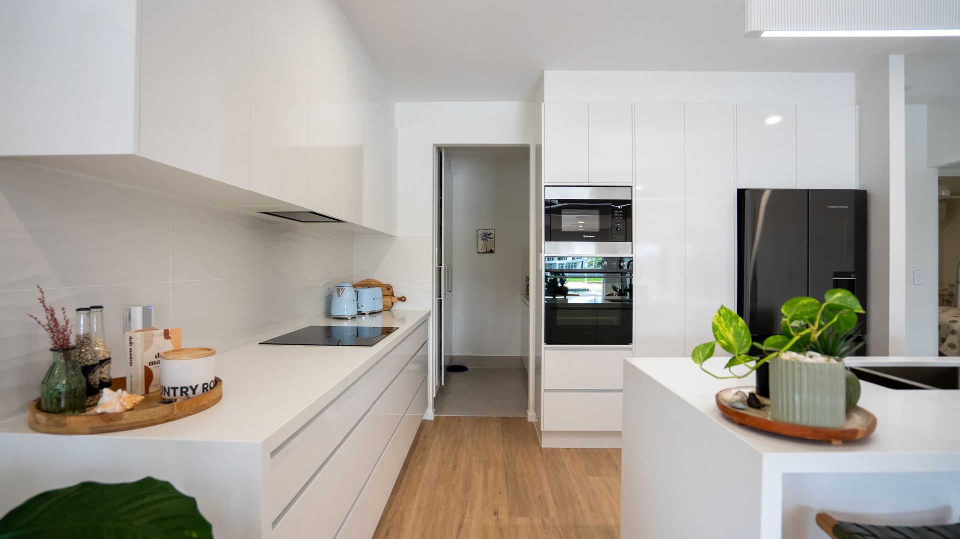 A kitchen with white cabinets and a black refrigerator.