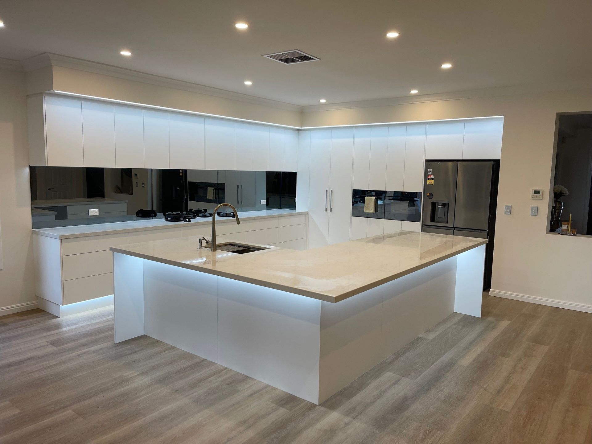 A kitchen with white cabinets and a large island in the middle.