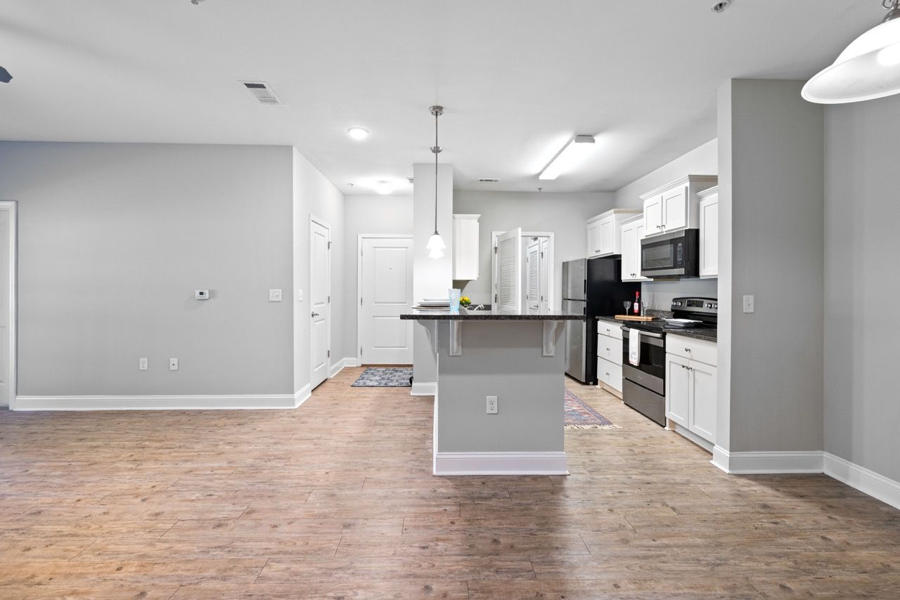 Open-concept kitchen with island, white cabinets, and stainless-steel appliances