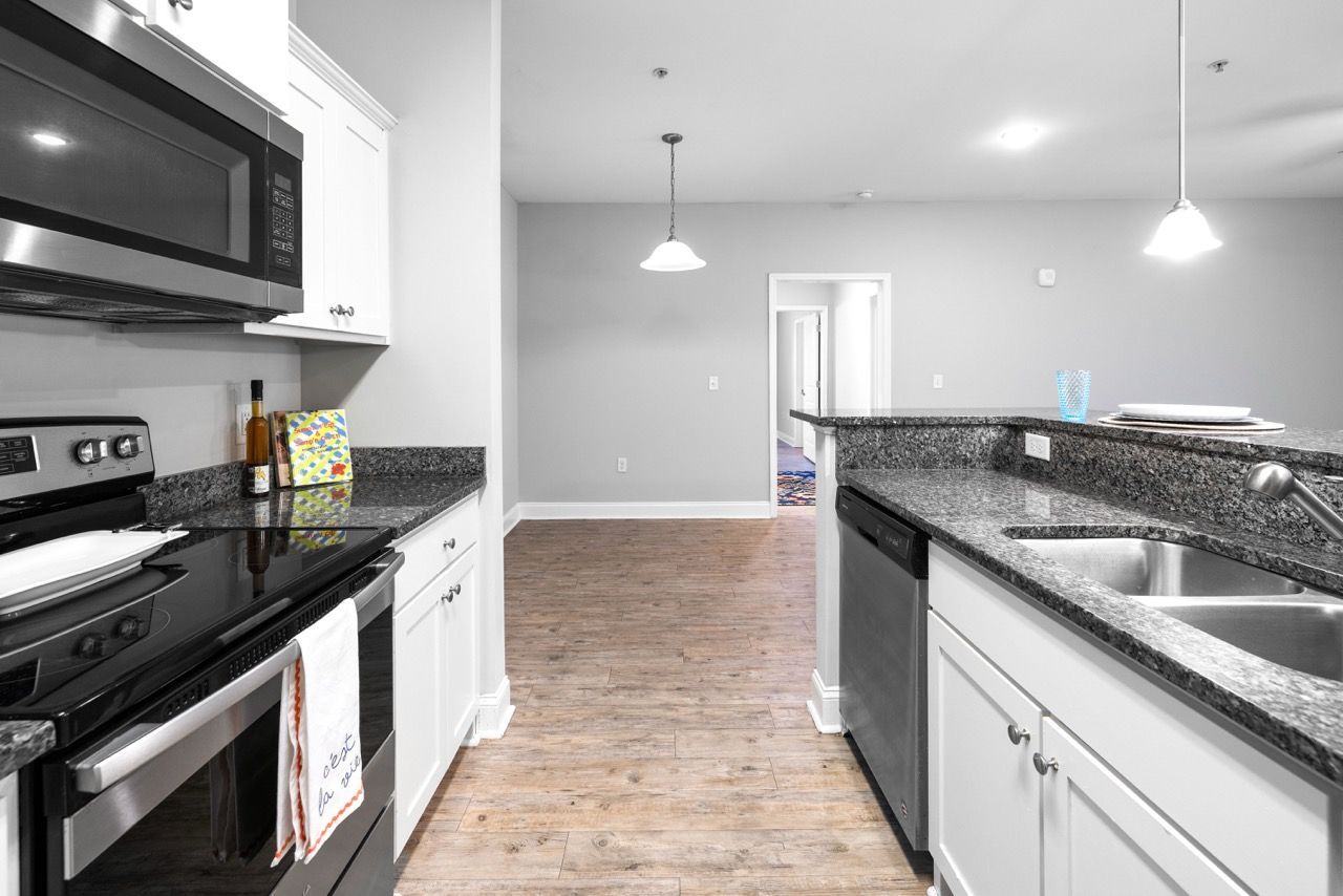 Open-concept kitchen with granite countertops, stainless steel appliances, and an island.
