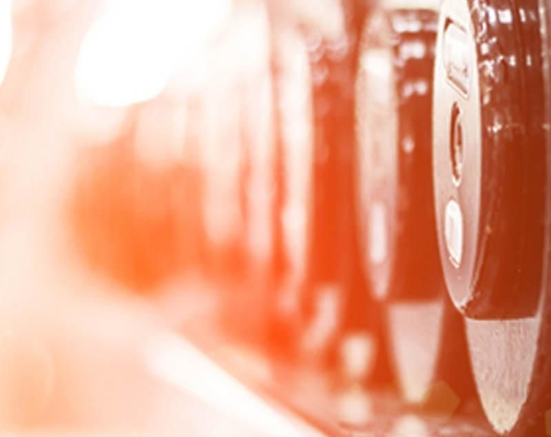 Primo piano dell'attrezzatura da palestra con un filtro arancione brillante e loghi in basso.