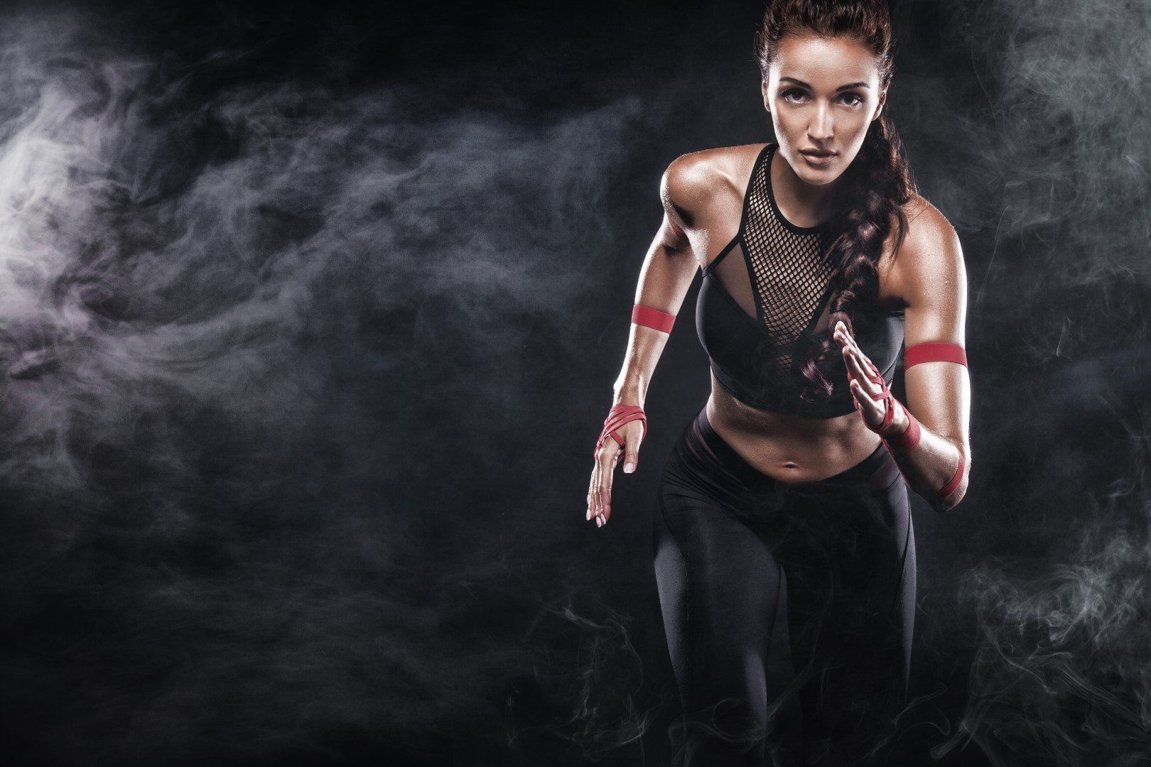 Donna in abbigliamento sportivo che corre, circondata da fumo scuro.