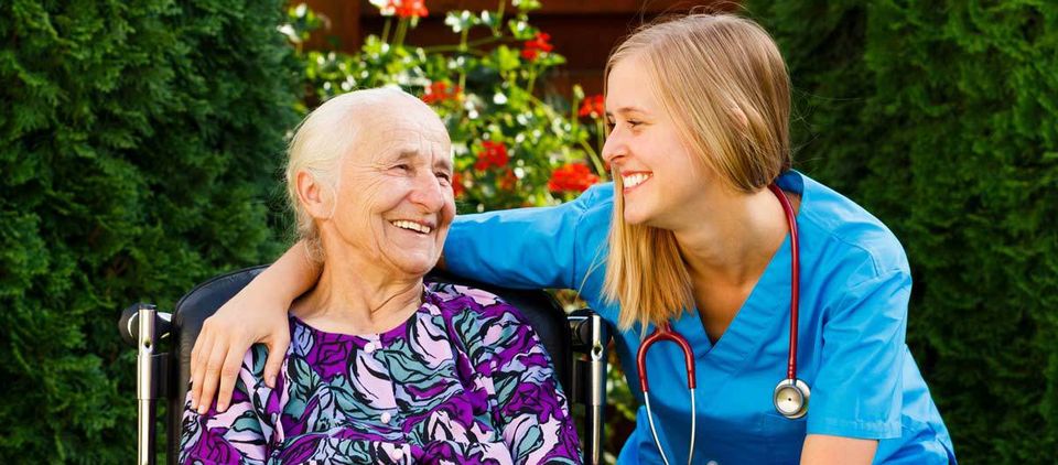 Supporting young doctor with elderly patient at nursing home