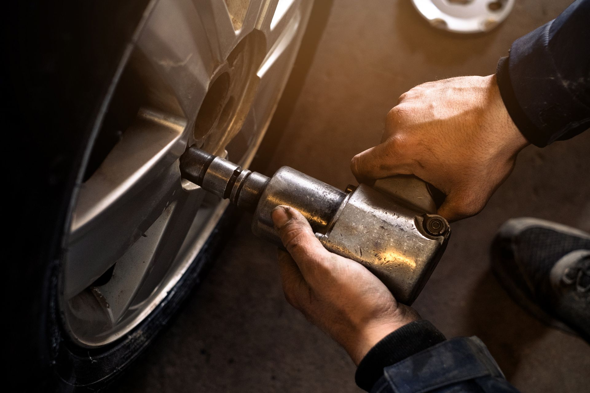 A person is using a wrench to change a tire on a car.