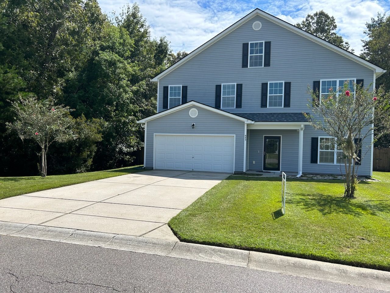 A large house with a garage and a driveway in front of it.