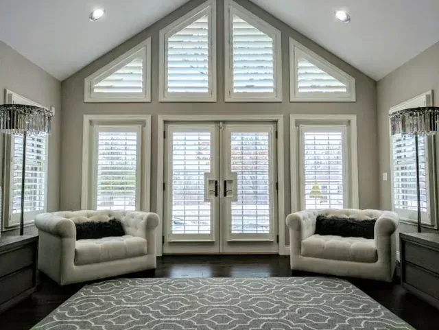 a living room with two chairs and a rug and a vaulted ceiling Love is Blinds Colorado window treatment solutions.