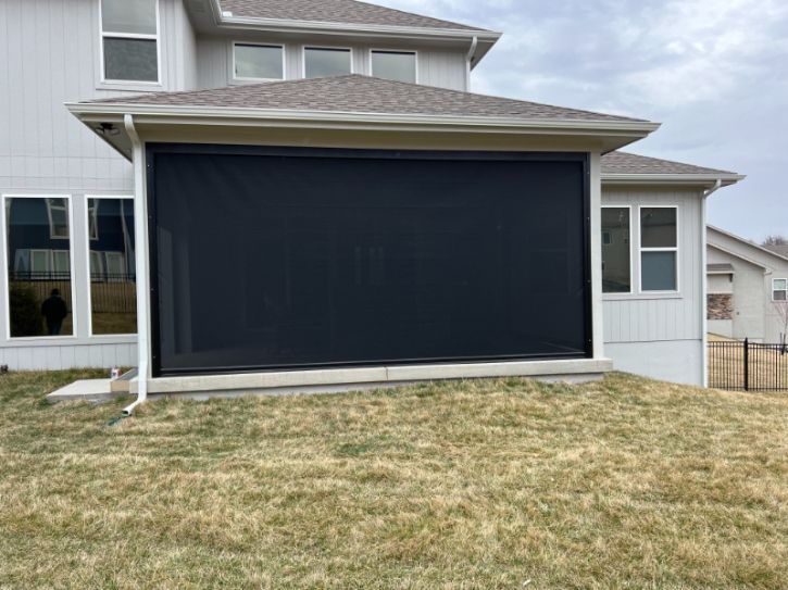 A home with an outdoor alcove has a patio shade for privacy. 