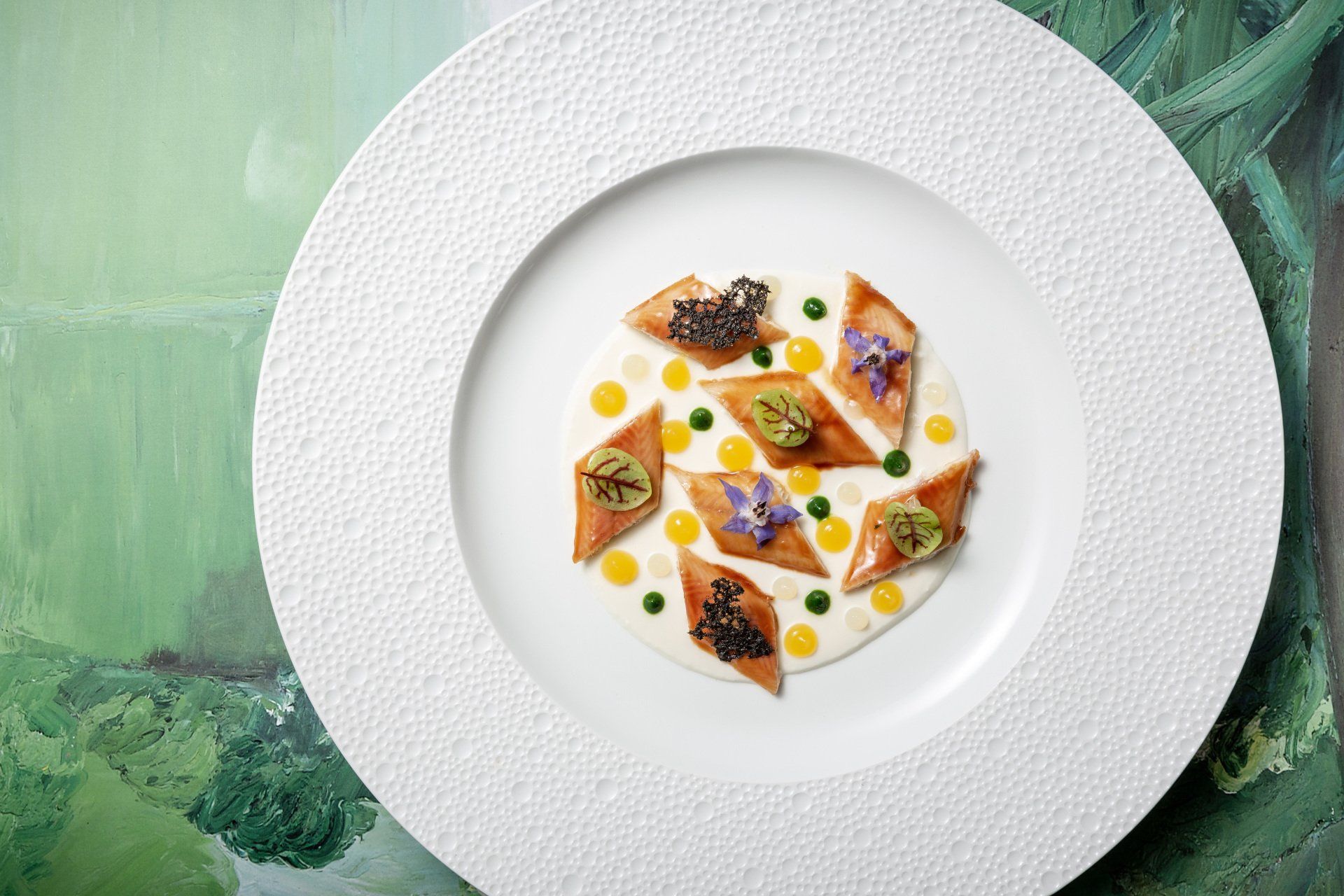 Une assiette blanche garnie d'une variété de plats sur fond vert.