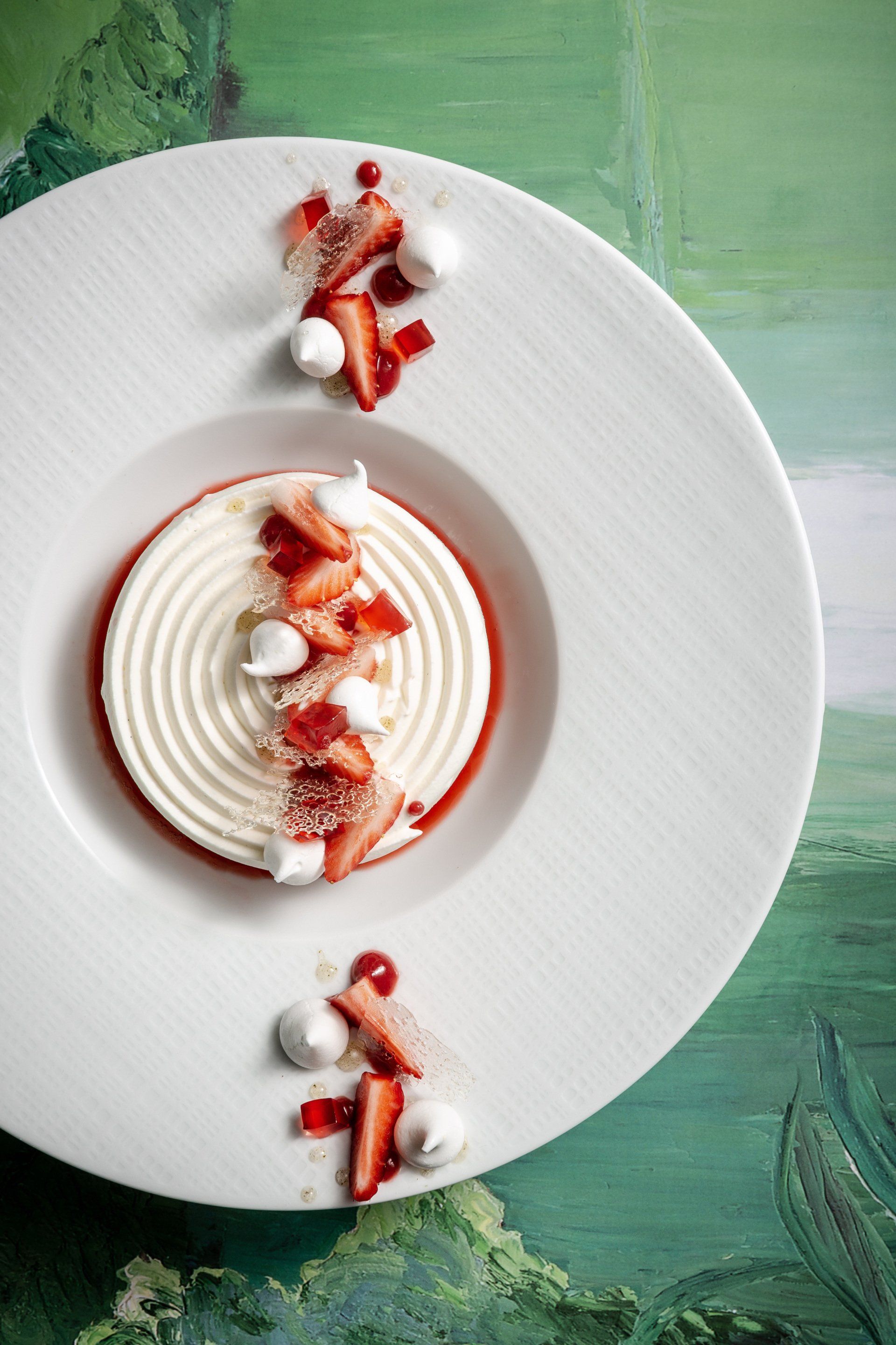 Une assiette blanche garnie d'un dessert aux fraises et à la crème fouettée.