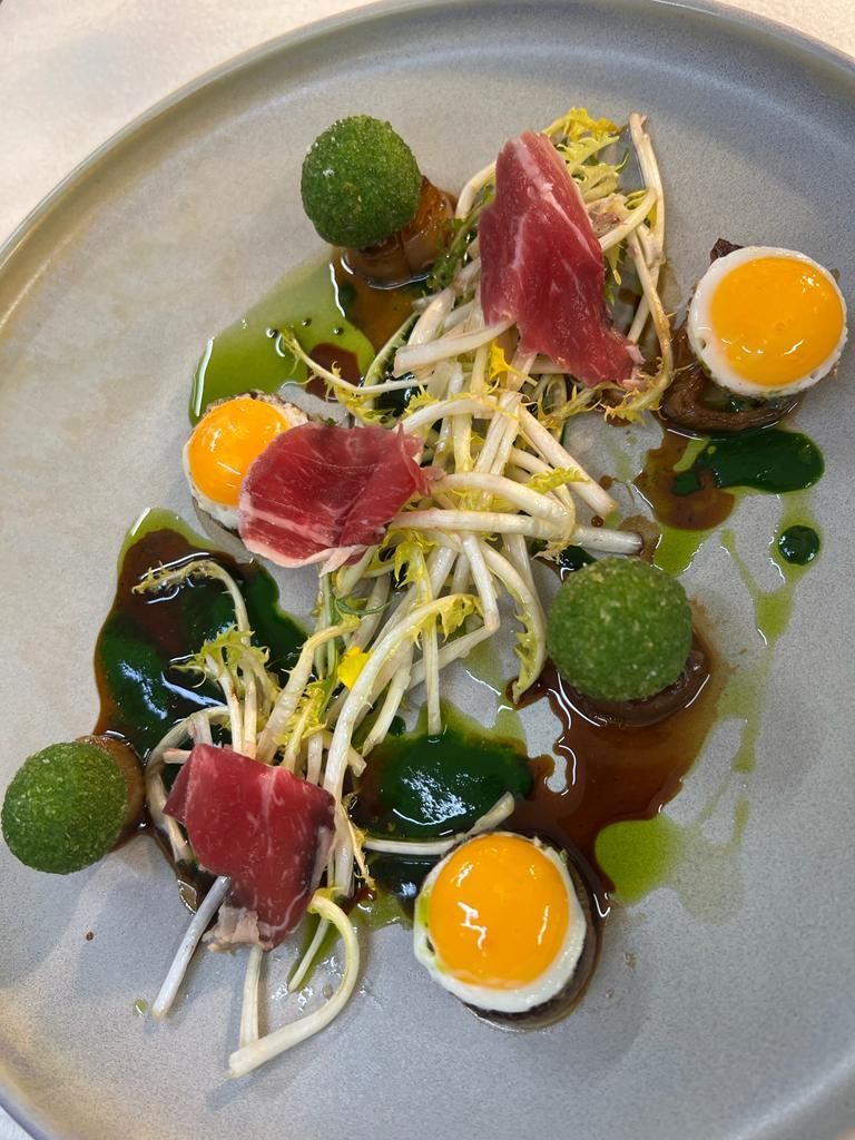 Un gros plan d'une assiette de nourriture avec des œufs et de la viande sur une table.