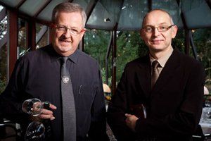 Deux hommes en costume-cravate se tiennent l'un à côté de l'autre.