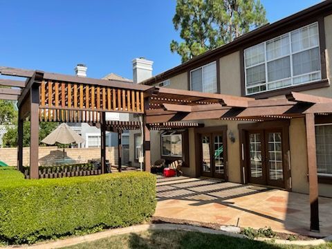 A large house with a pergola in the backyard.