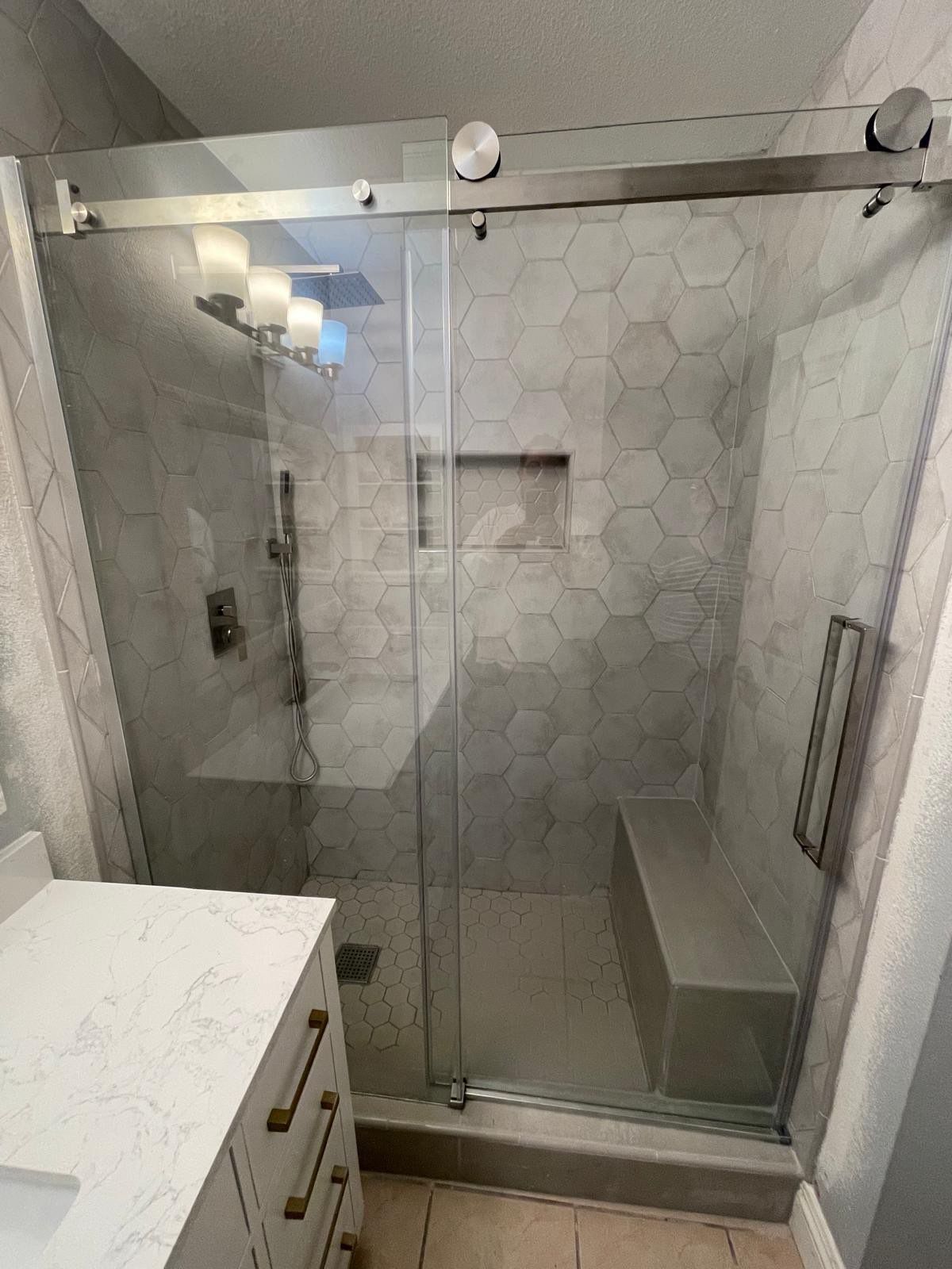 A bathroom with a sliding glass shower door and a sink.