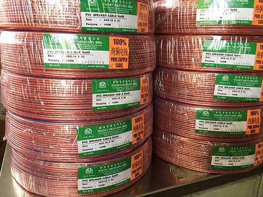Spools of copper wire wrapped in plastic with labels, stacked on a shelf.