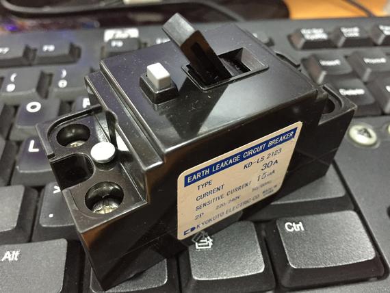Black earth leakage circuit breaker on a keyboard, labeled 