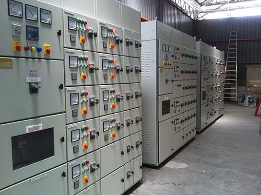 Electrical control panels lined up in an industrial setting.