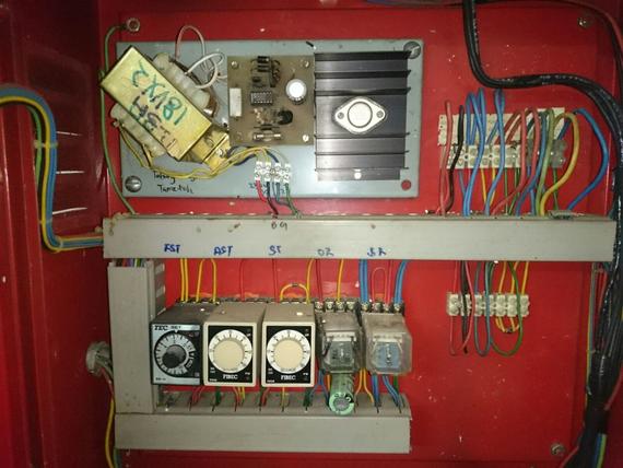 Red control panel with timers, wiring, and electronic components.