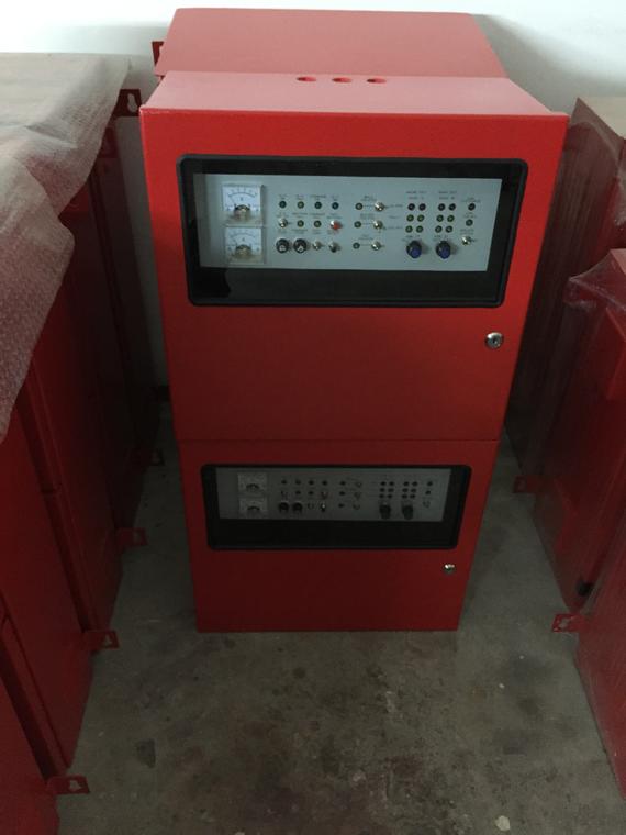 Red electrical control panel cabinet with various knobs, switches, and meters.