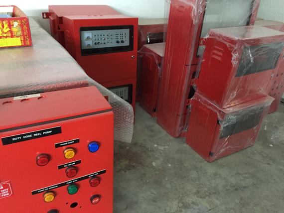 Red electrical control panels, likely for fire systems, in an indoor setting.