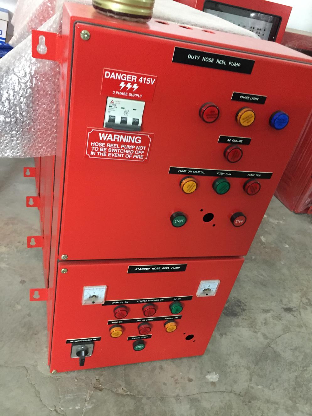 Red electrical control panel with gauges, buttons, and warning labels.