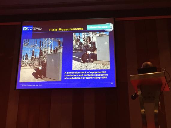 Slide presentation showing field measurements, including photos of equipment. A speaker is on stage.