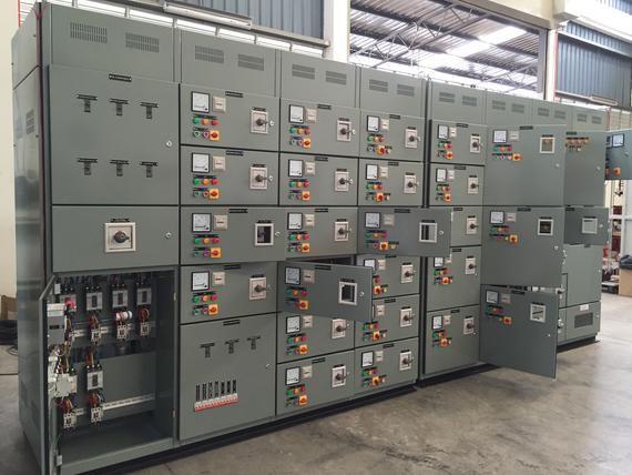 Gray electrical control panel with open doors, displaying meters, switches, and wiring.