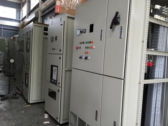 Electrical control panels in a warehouse. Gray metal cabinets with buttons, switches, and gauges.