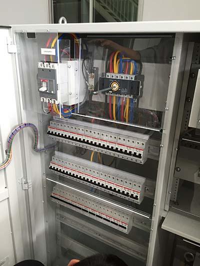 Electrical panel with wires and circuit breakers.