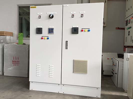 White electrical control panel with meters, switches, and vents. Indoors.