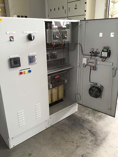 Electrical cabinet with open door, showing internal components, wiring, and a cooling fan.
