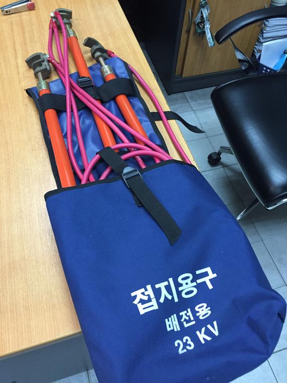 Blue bag holding orange and pink electrical safety sticks. Text reads 