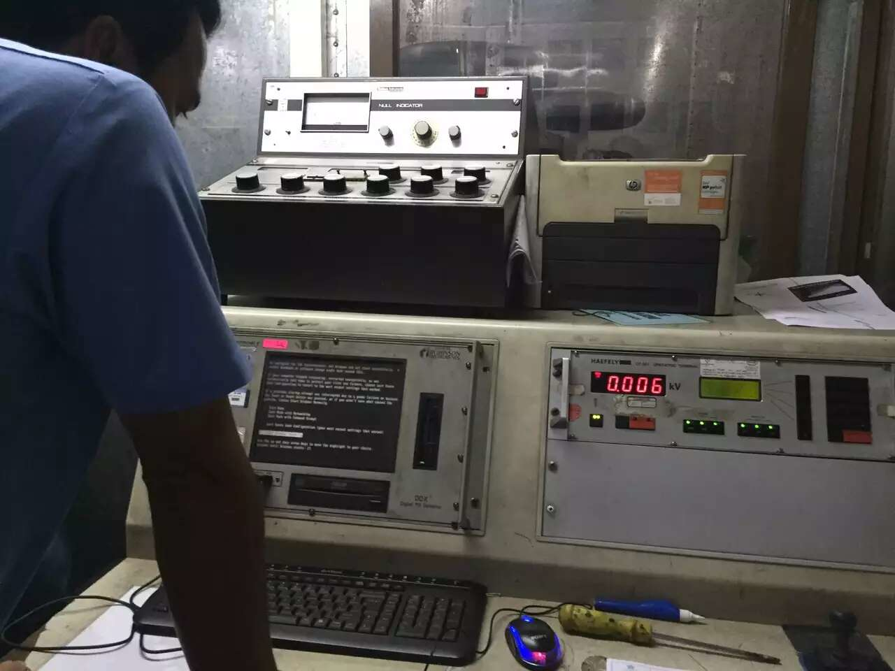 Person operates control panel with digital displays and knobs.