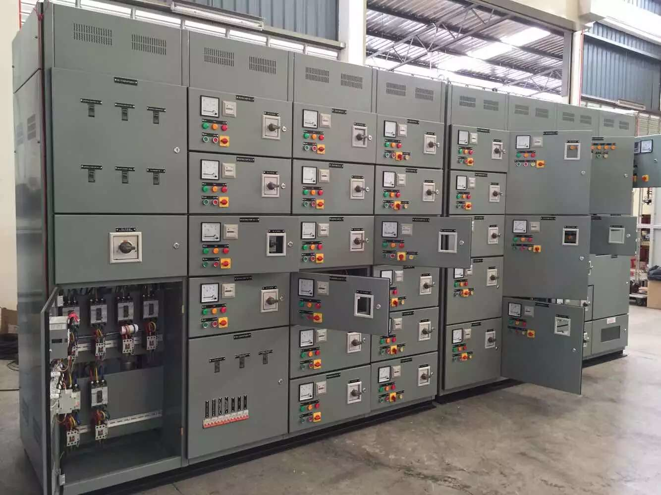 Gray electrical control panels with multiple meters, switches, and circuit breakers.