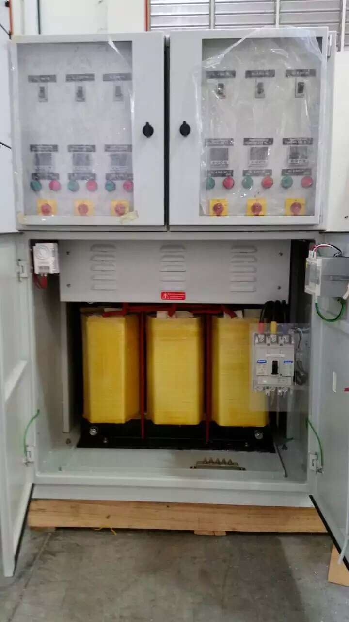 Electrical cabinet with open doors, containing yellow transformers and circuit breakers.