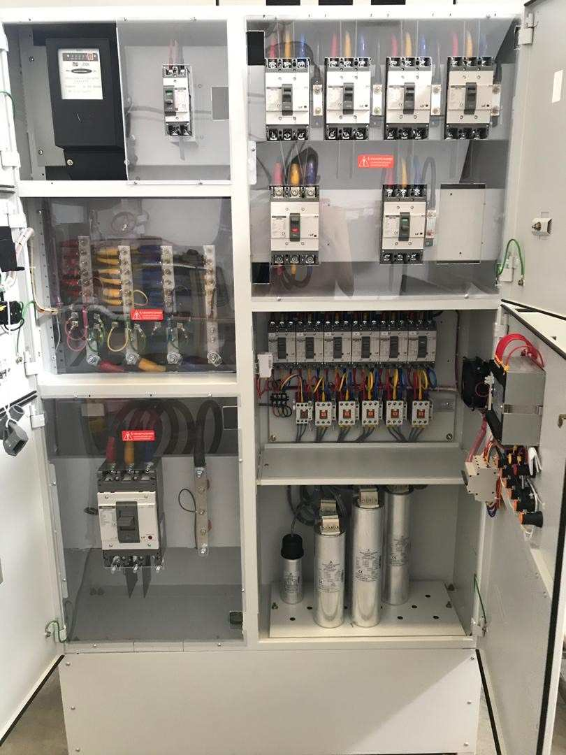 White electrical panel cabinet with various circuit breakers, wiring, and other components.