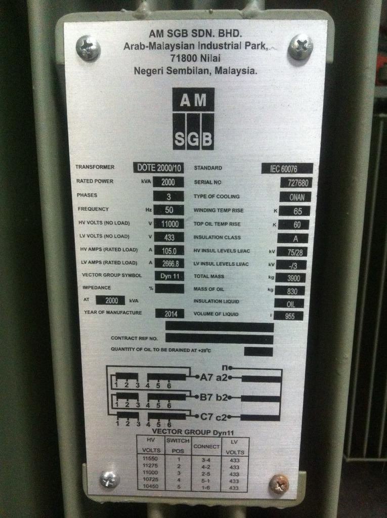 Metal equipment tag with technical specifications, affixed to a green surface, likely on industrial machinery.