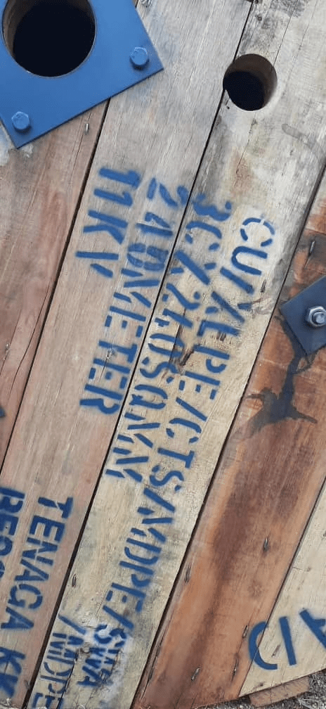 Wooden cable spool with blue text: 