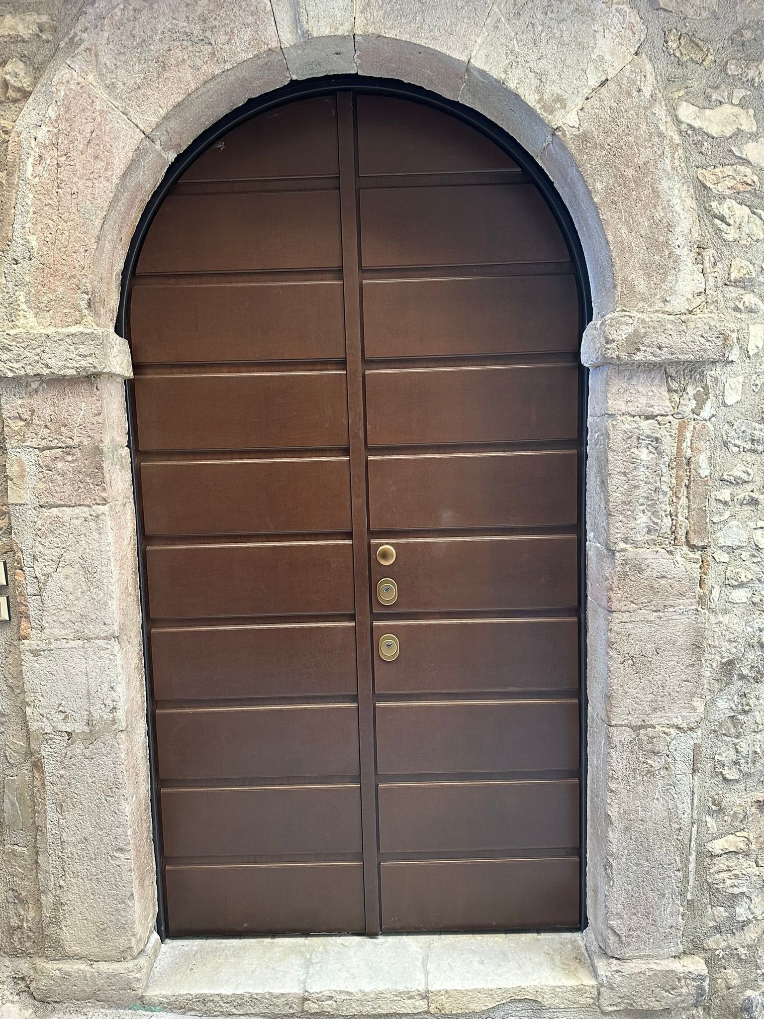 Due porte interne: una nera con finestre quadrate, l'altra in vetro con un disegno circolare.