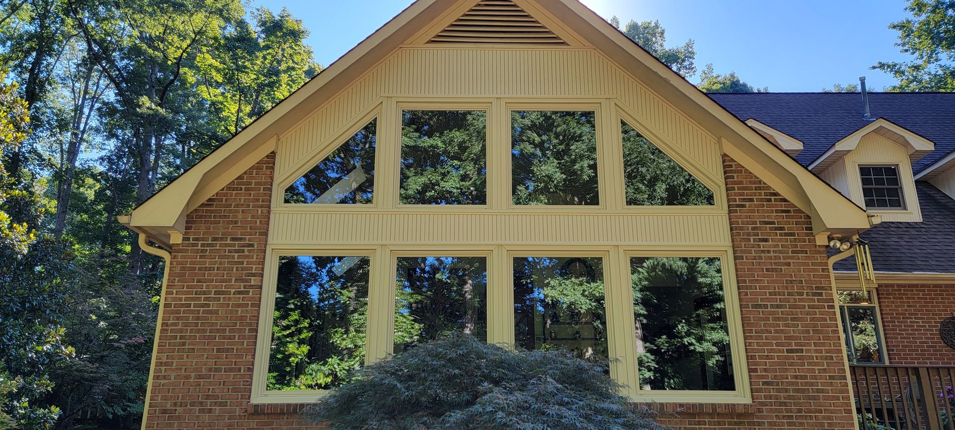 A brick house with a wooden roof and a lot of windows.