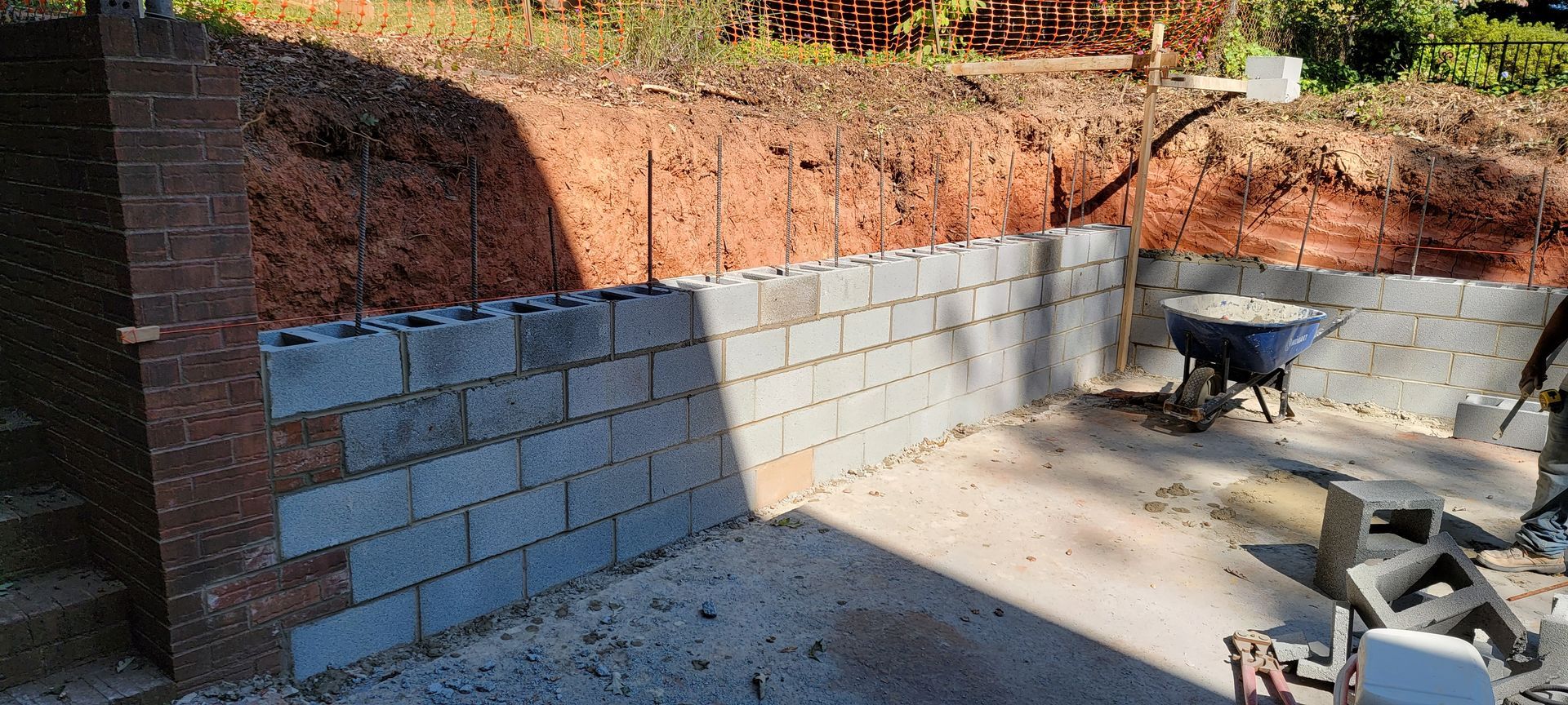 A brick wall is being built next to a wheelbarrow.