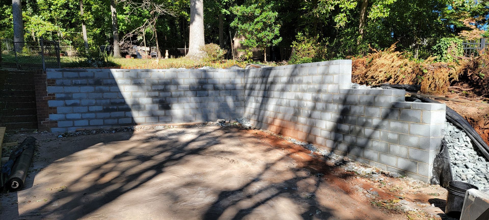 A brick wall is being built in the middle of a forest.